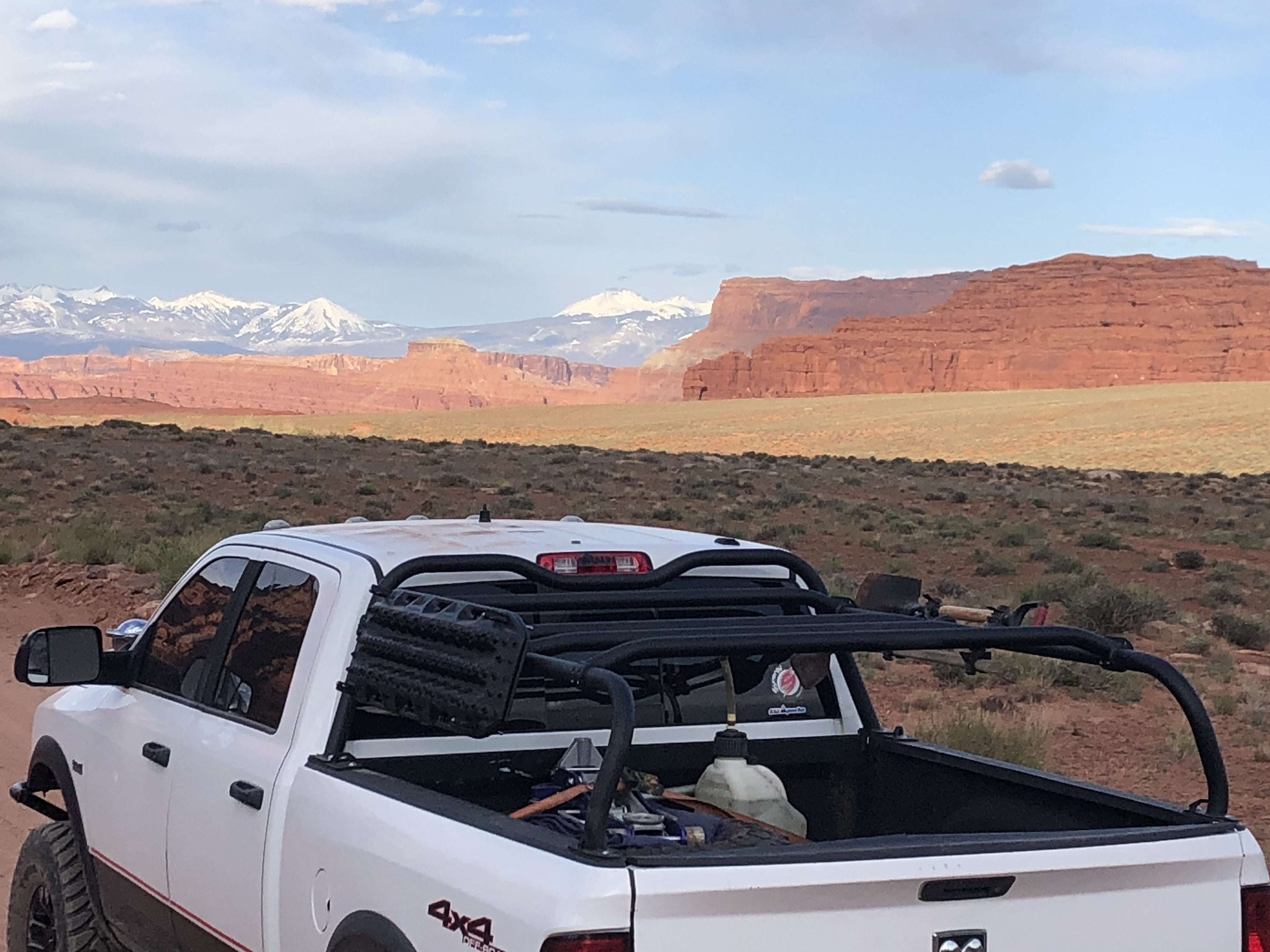 White Power Wagon in a desert basin with snowy peaks behind, rack loaded with gear