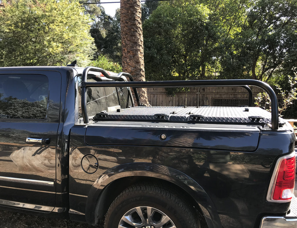 Side view of a black Ram with a flat cargo tray mounted across the rack