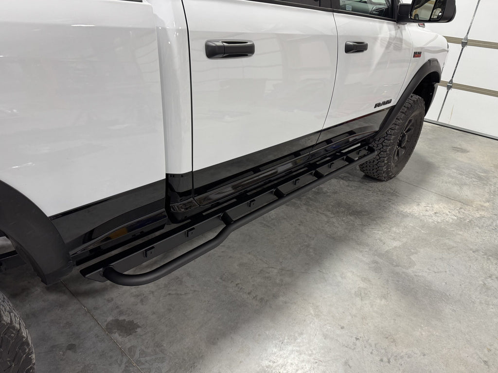 Slider fitted along the rocker of a white Ram in a garage, seen from the front wheel back