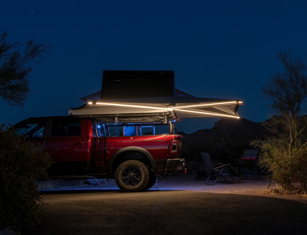 Red Ram at night in the desert, a strip light running the length of the open awning