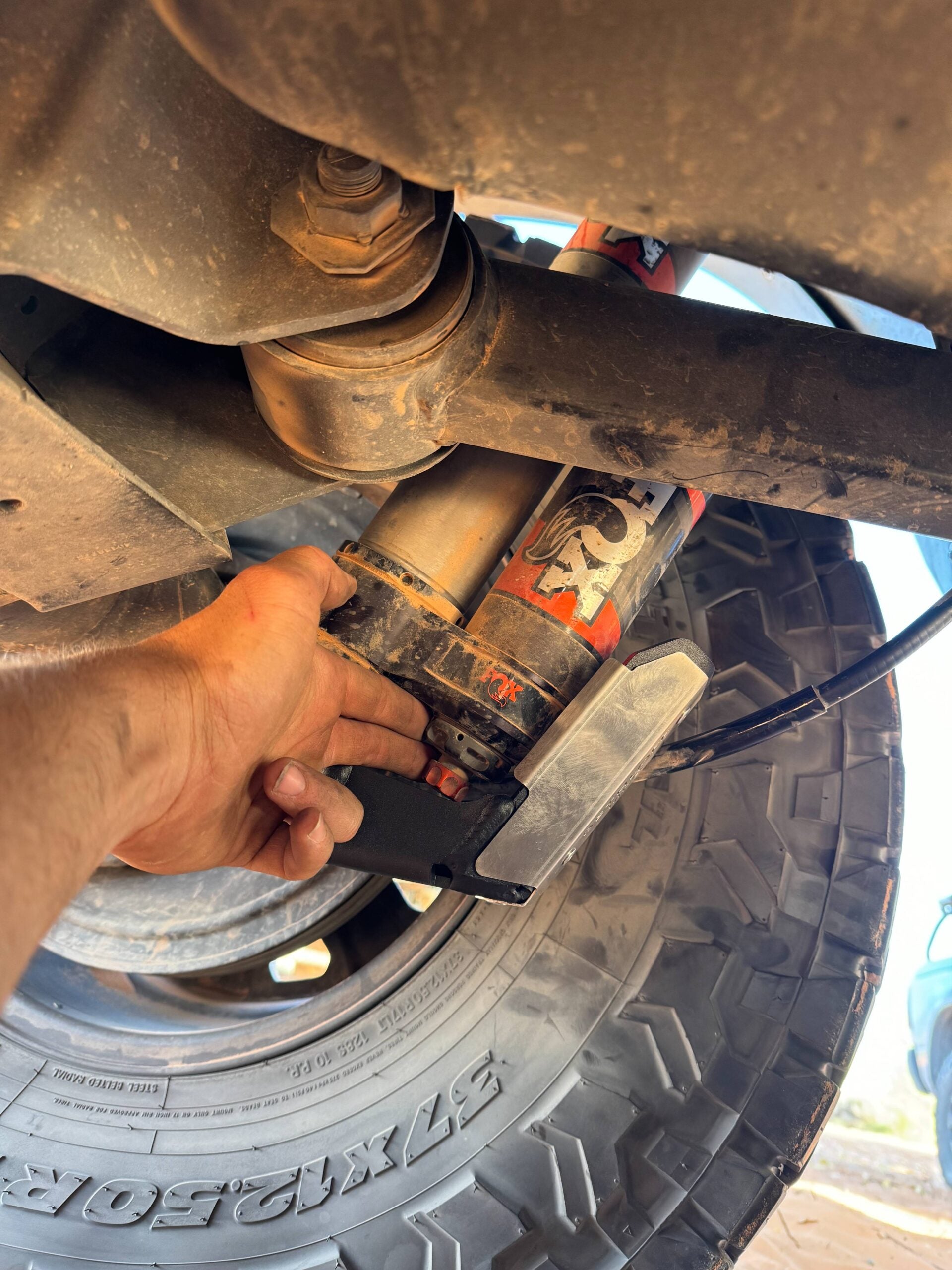 A hand holding the guard up against the shock body to show the fit