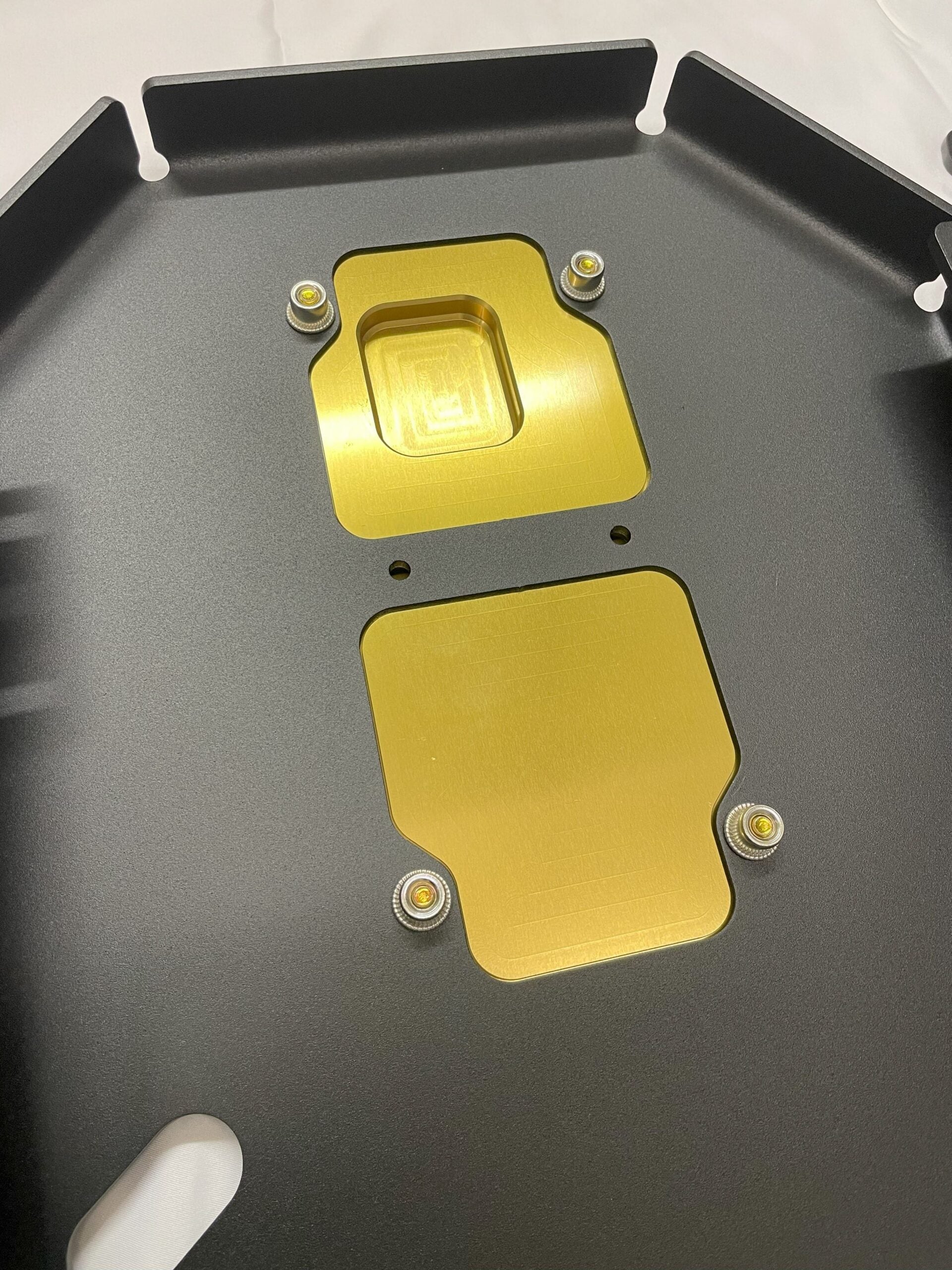Two gold service panels set into the black plate, seen from above