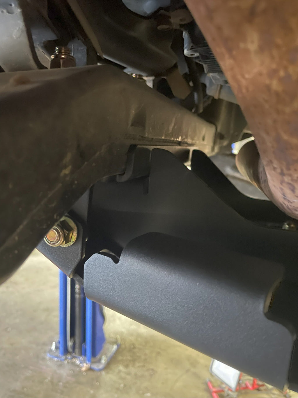 Side edge of the fitted plate, a blue jack standing under the truck behind it