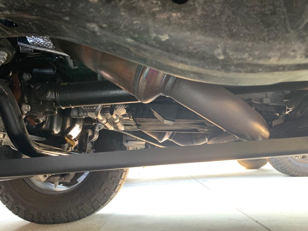Under the truck looking back along the exhaust with the edge of the plate at the left