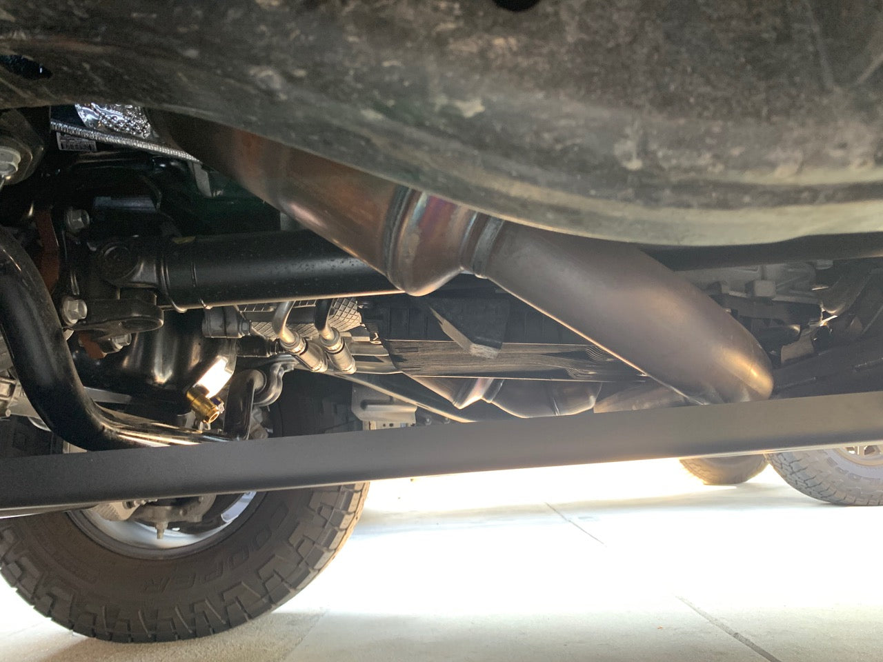Under the truck looking back along the exhaust with the edge of the plate at the left