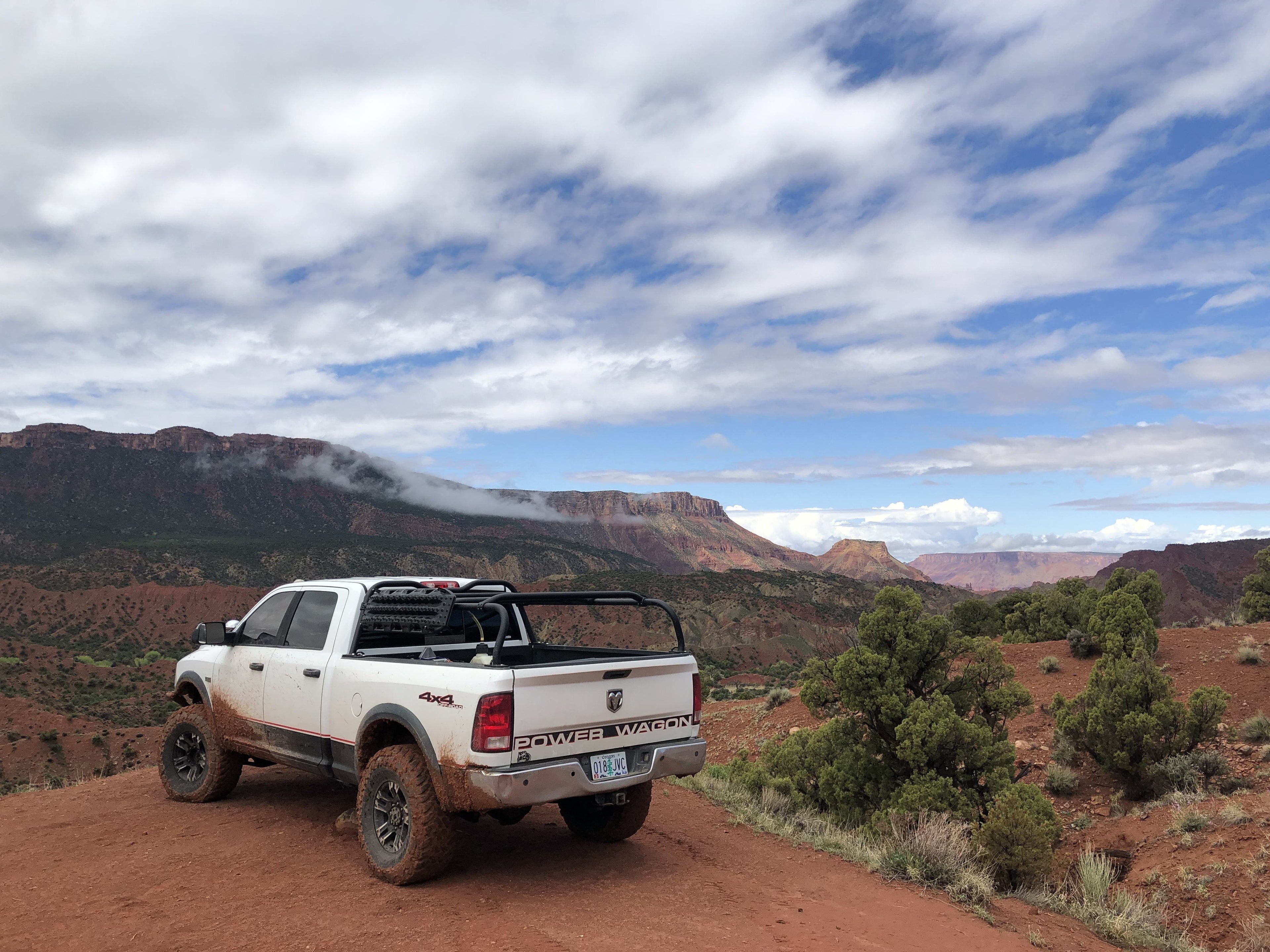 White Power Wagon on a red dirt track high above a canyon, rack fitted