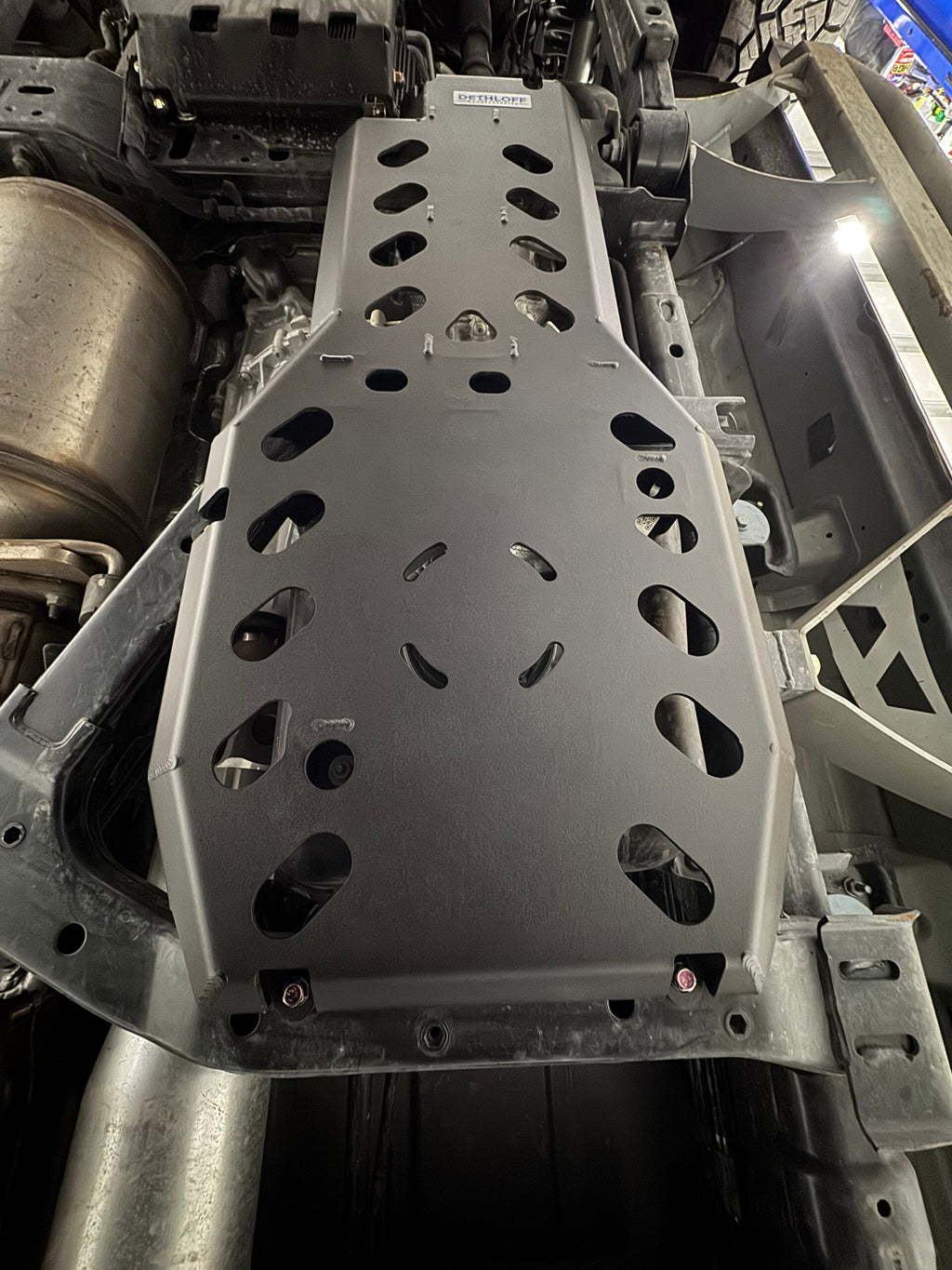 The guard fitted under the truck between the frame rails, exhaust running alongside