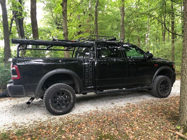 Side view of the black Power Wagon in the woods, basket and bike carriers on the rack