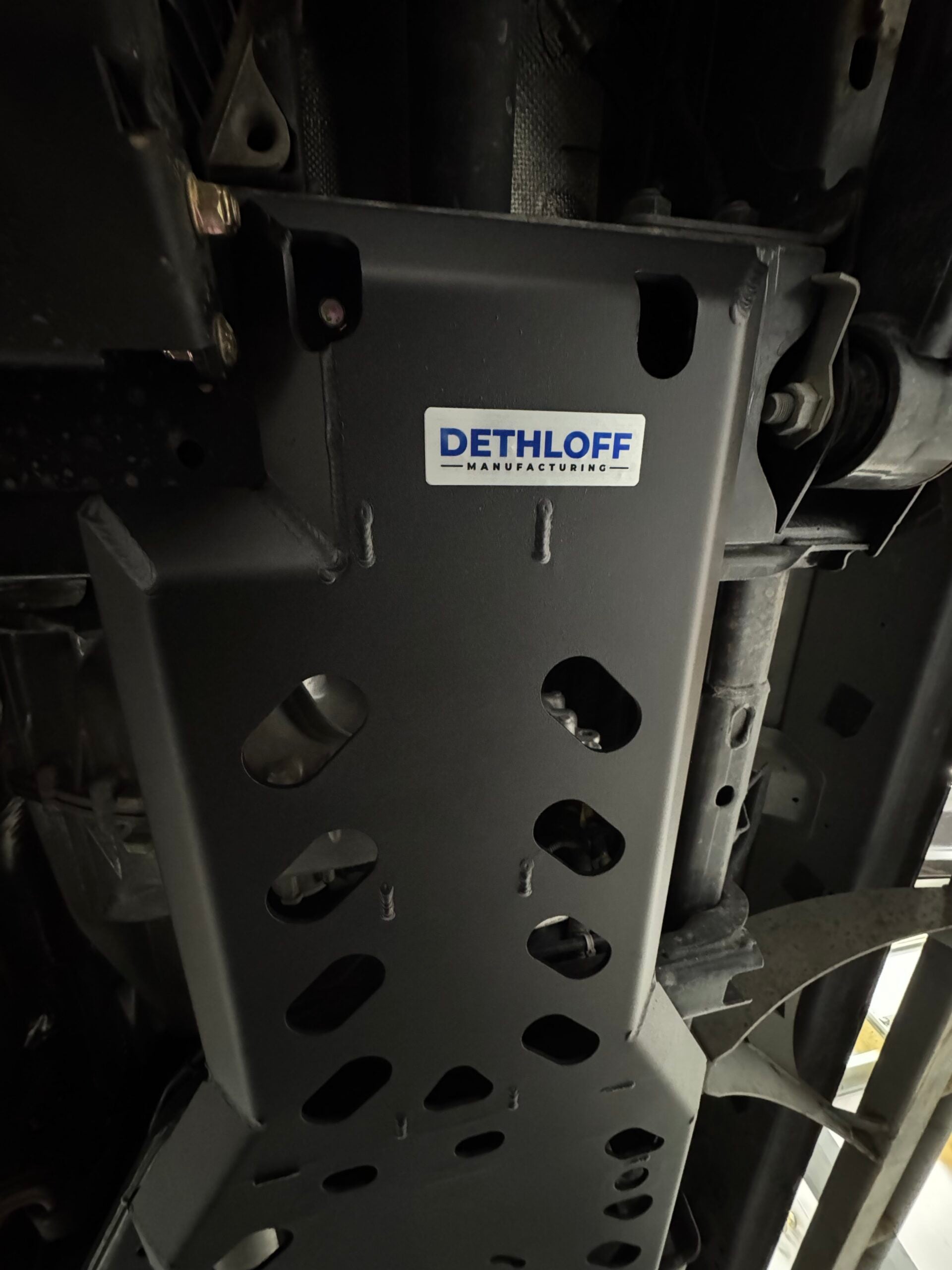The guard bolted under the truck, DETHLOFF Manufacturing badge on its face