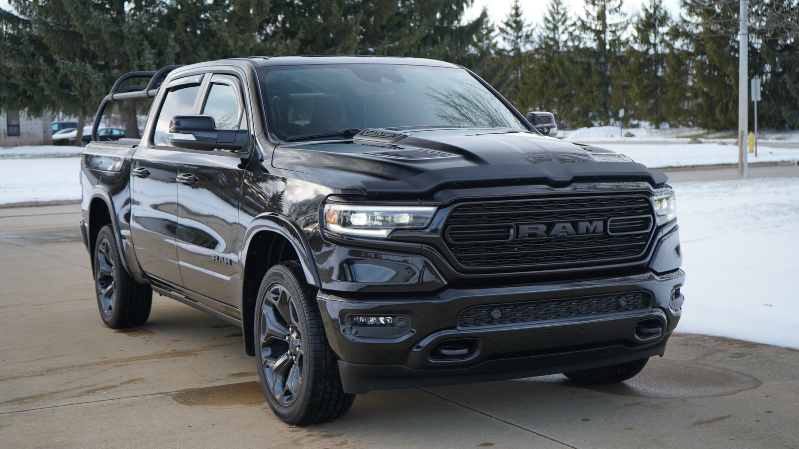 Front quarter of the black Ram 1500 from the opposite side, rack behind the cab