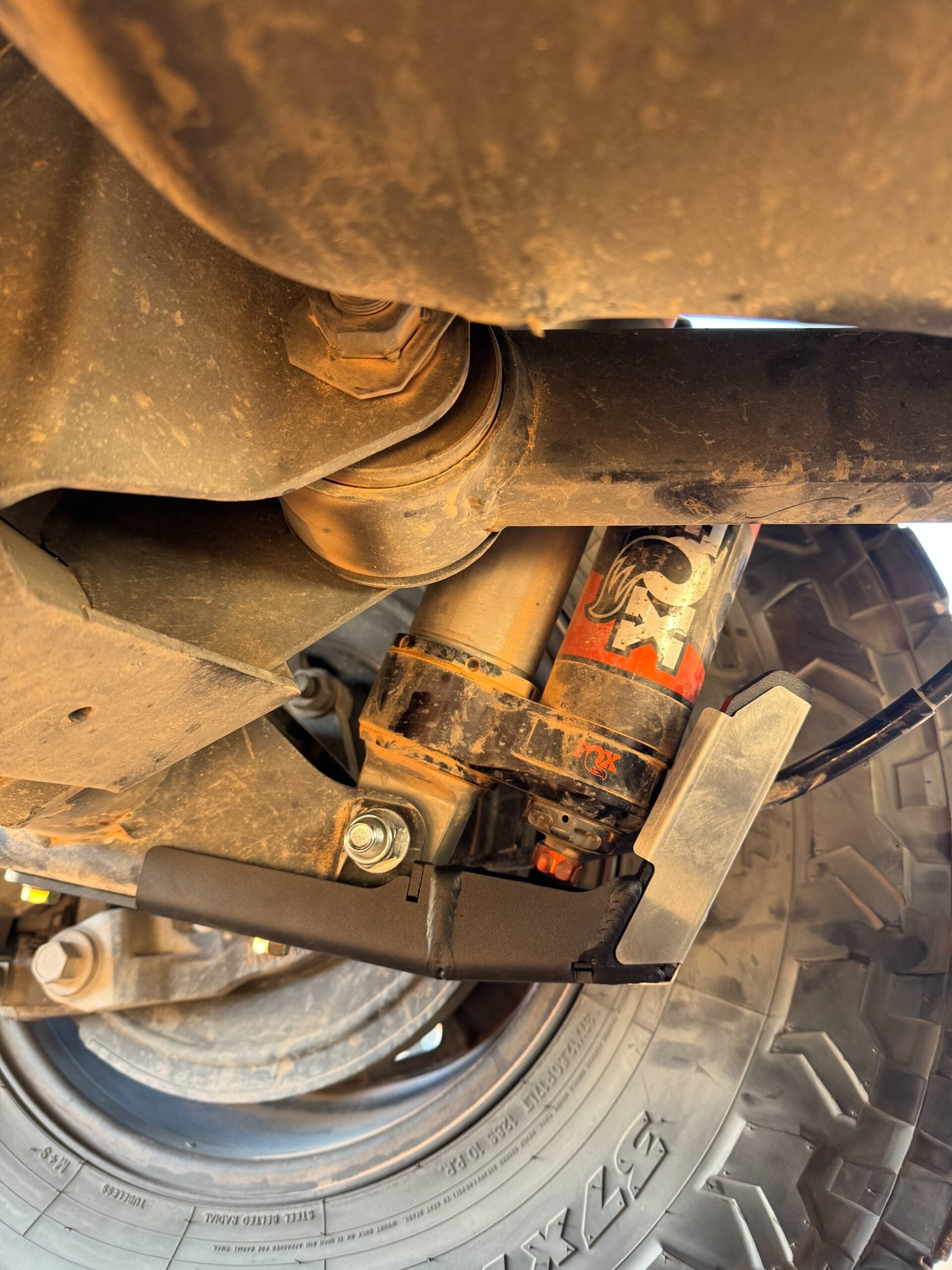 Guard fitted beside a Fox shock, seen from under the rear axle