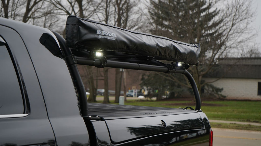 Close view of a rolled awning in its cover strapped along the rack's side rail