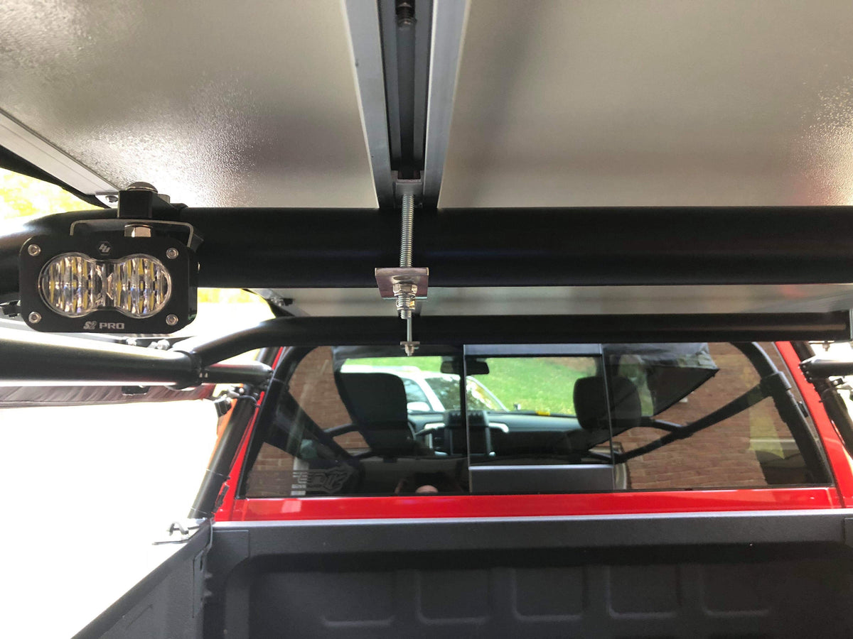 A pod clamped to the rack's cross tube, seen from behind through the rear window