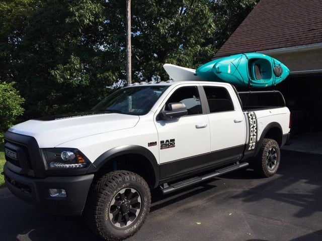 Front quarter of the white Power Wagon, a teal kayak loaded overhead on the rack
