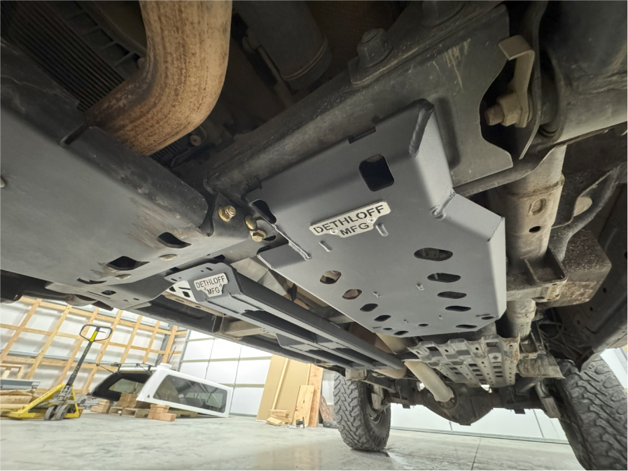 Wide view under the truck on a lift with the guard and neighbouring plates in place
