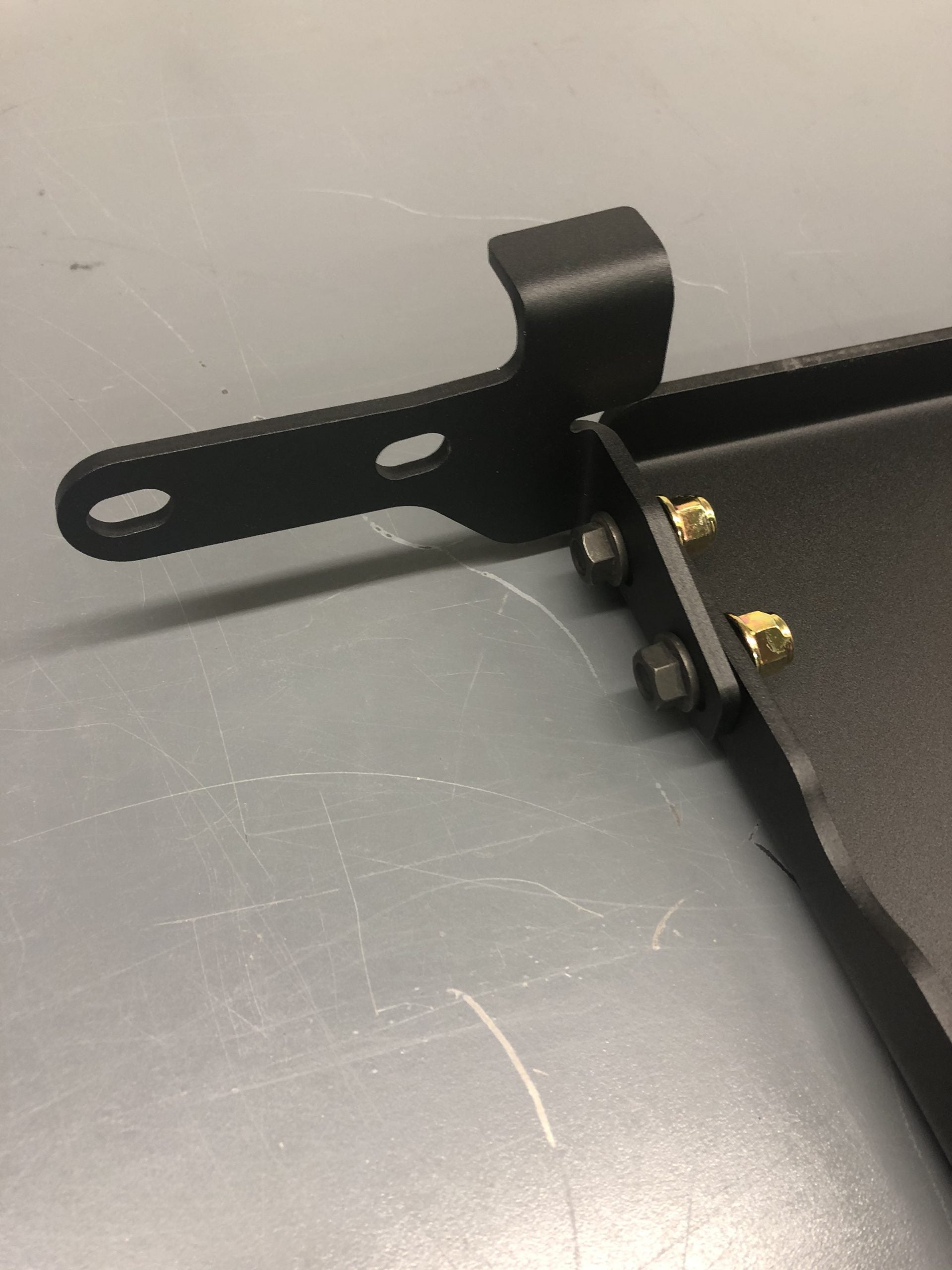 Close view of a mounting bracket bolted to the edge of the plate