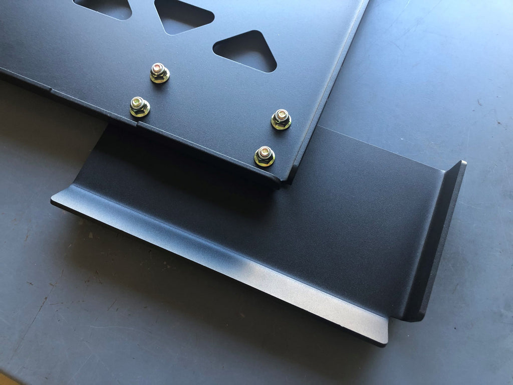 Two plate sections bolted together on a bench, folded flanges along the seam