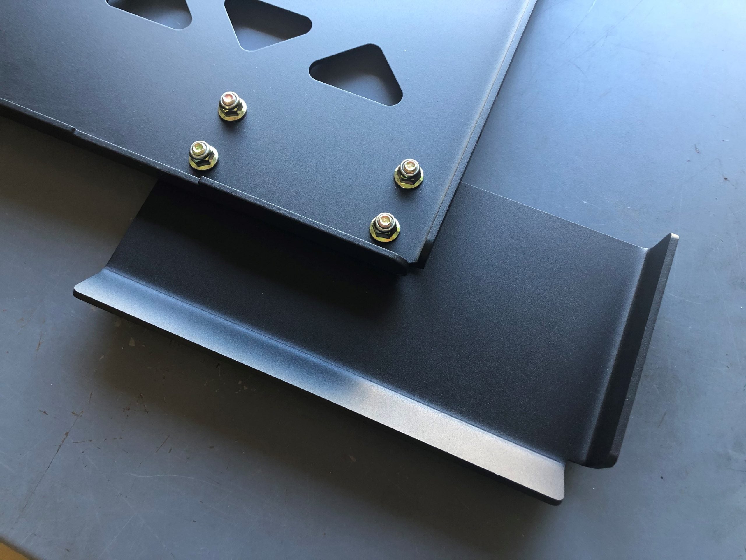 Two plate sections bolted together on a bench, folded flanges along the seam