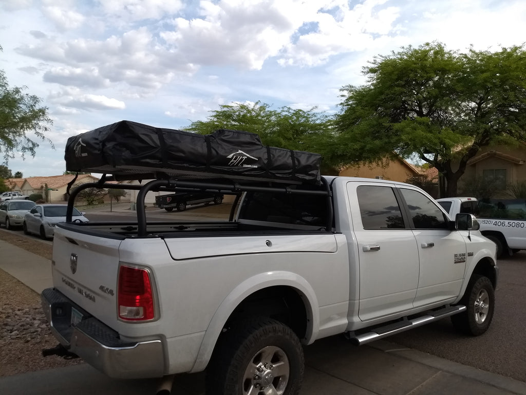 Rear quarter of the white Ram with the closed roof tent overhead