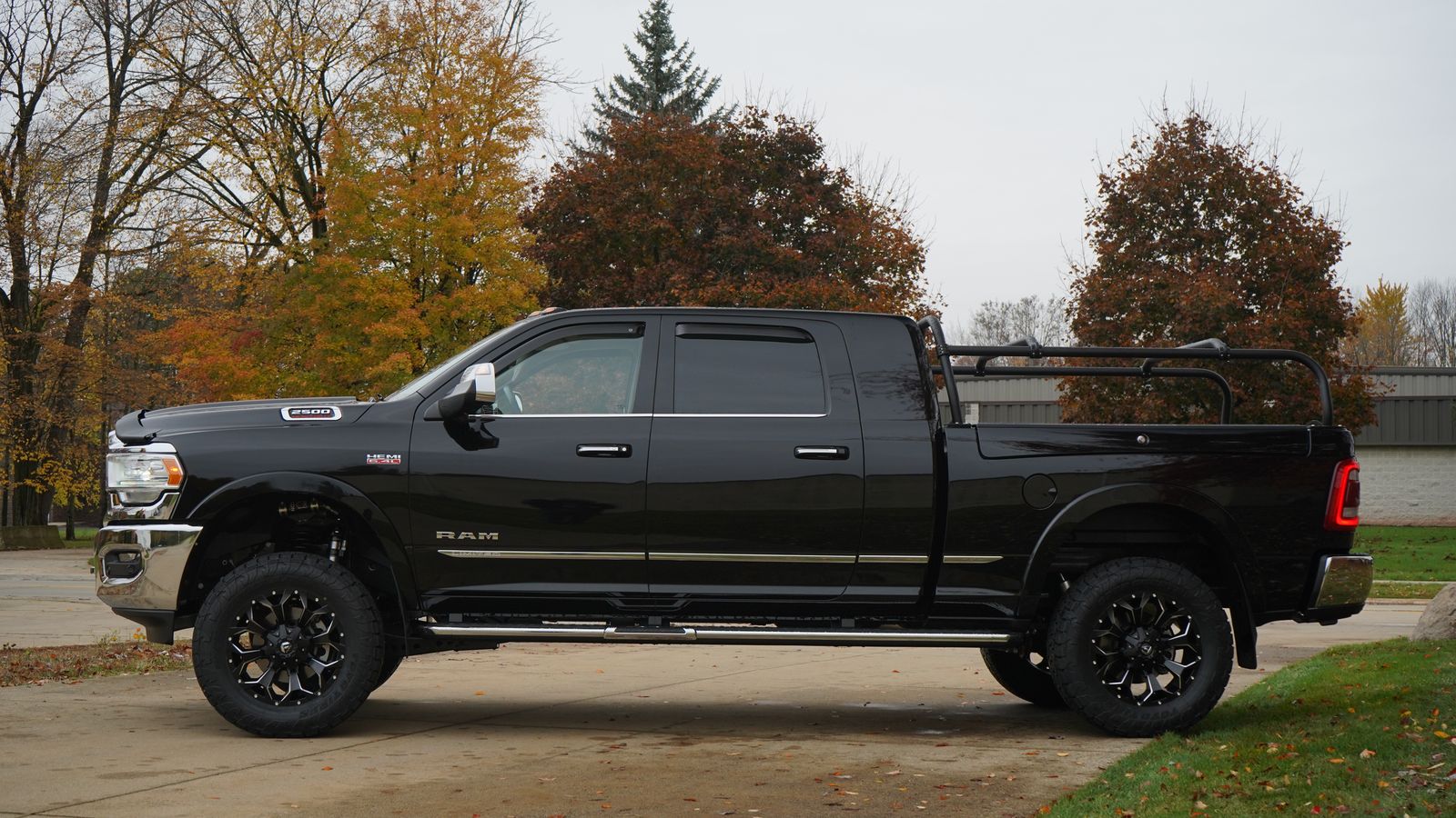 Side view of the black Ram from the opposite side, rack over the bed and fall color behind