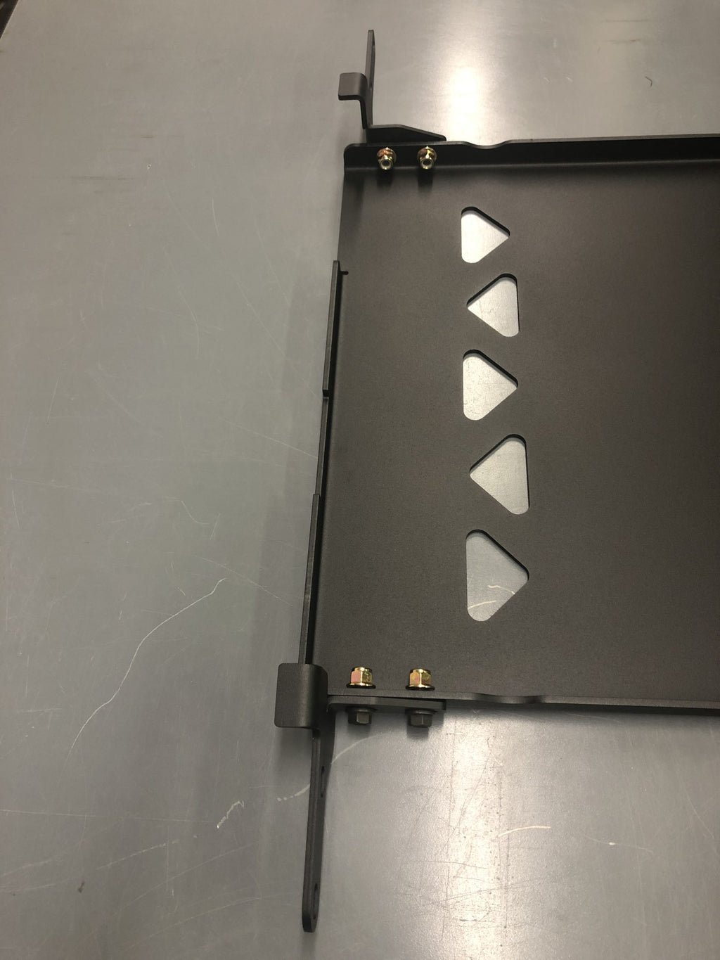 The plate on a bench with its side bracket and support bar bolted on