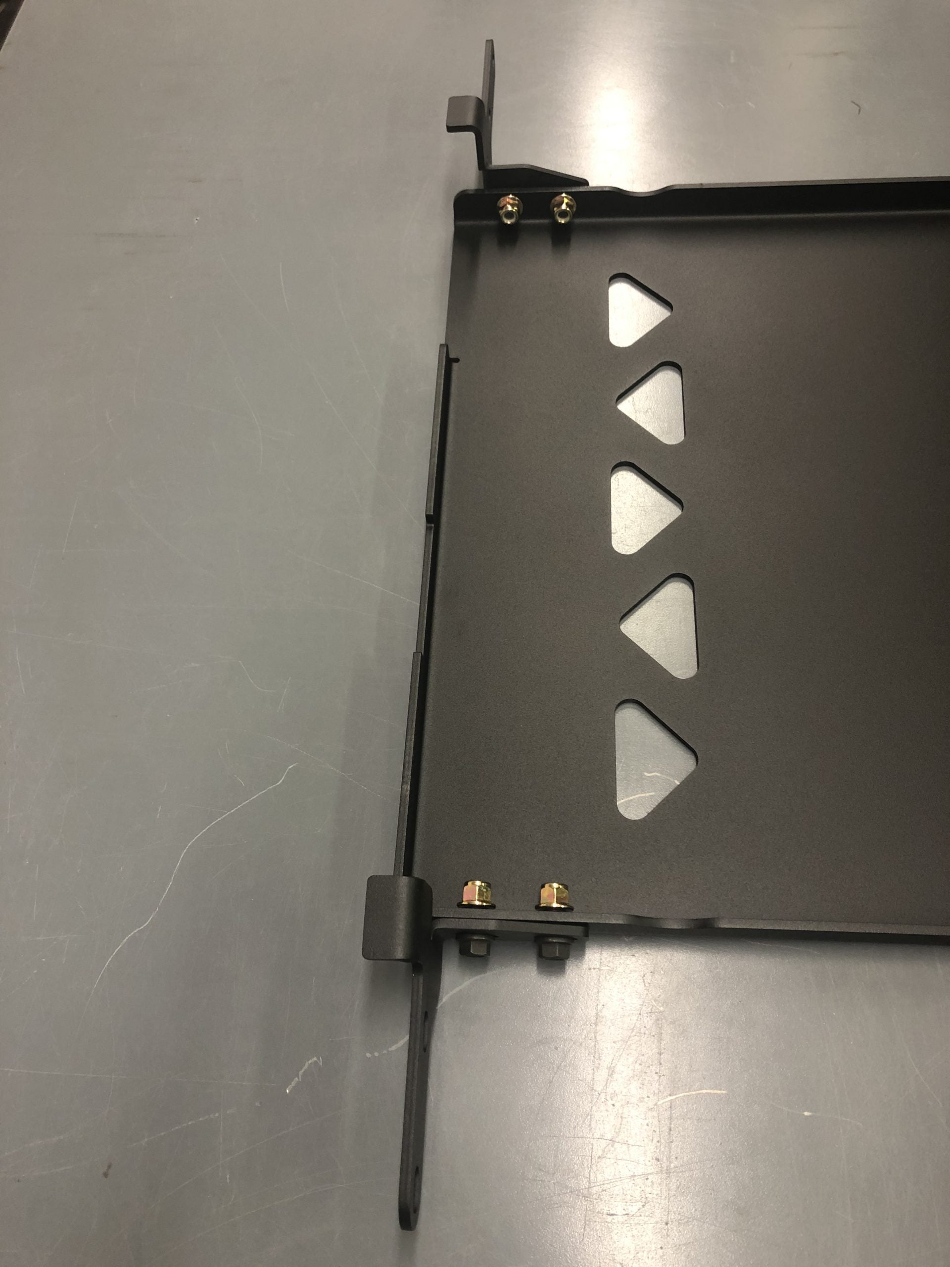 The plate on a bench with its side bracket and support bar bolted on