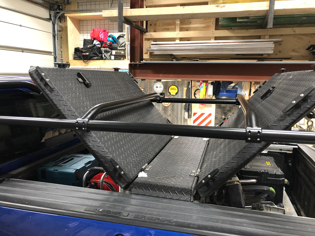 Looking up from inside the bed at the tonneau panels folded open under the crossbars
