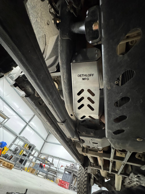 The guard in place along the frame rail with DETHLOFF MFG stamped into the aluminium above the slots