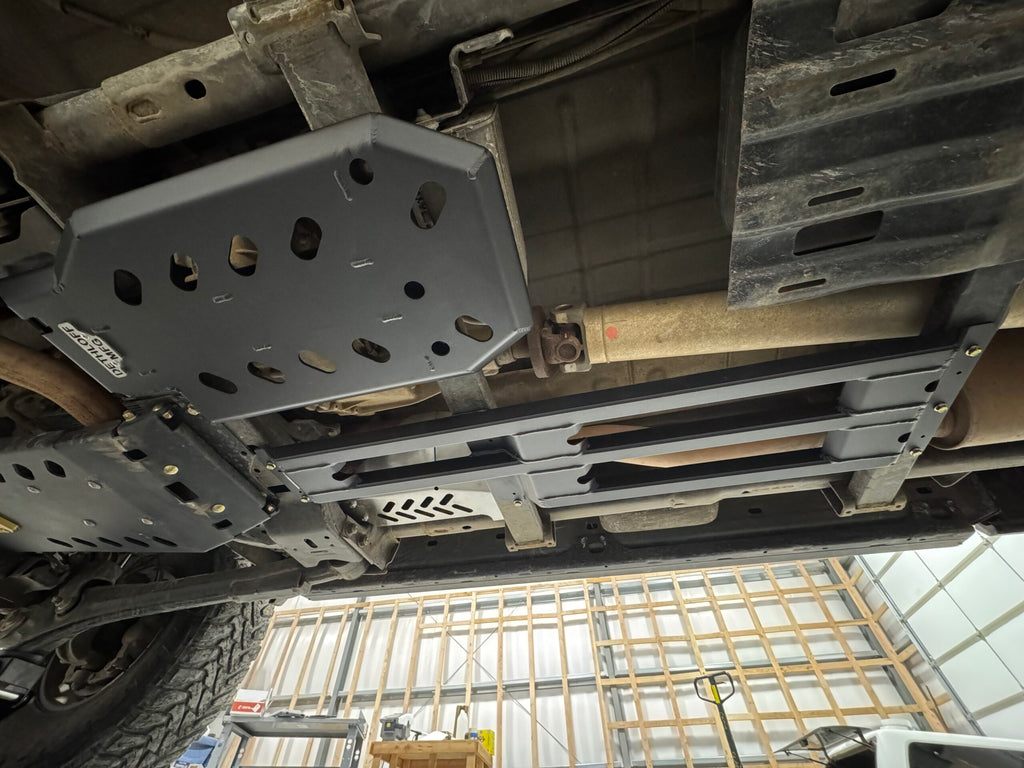 The underside along the frame rail, guard and skid plates in place either side of the driveshaft