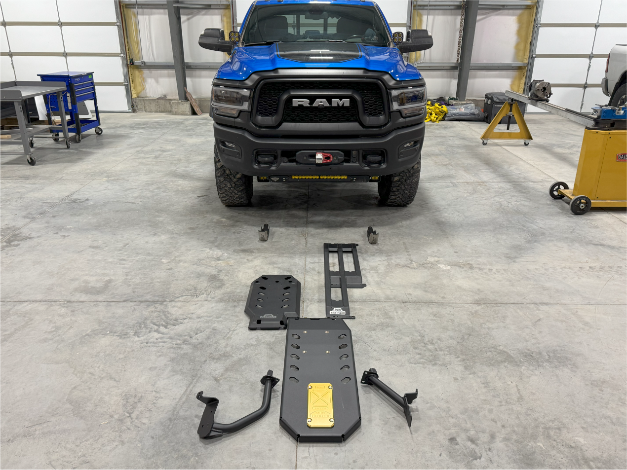 The full armor kit laid out in the shop in front of a blue Ram 2500