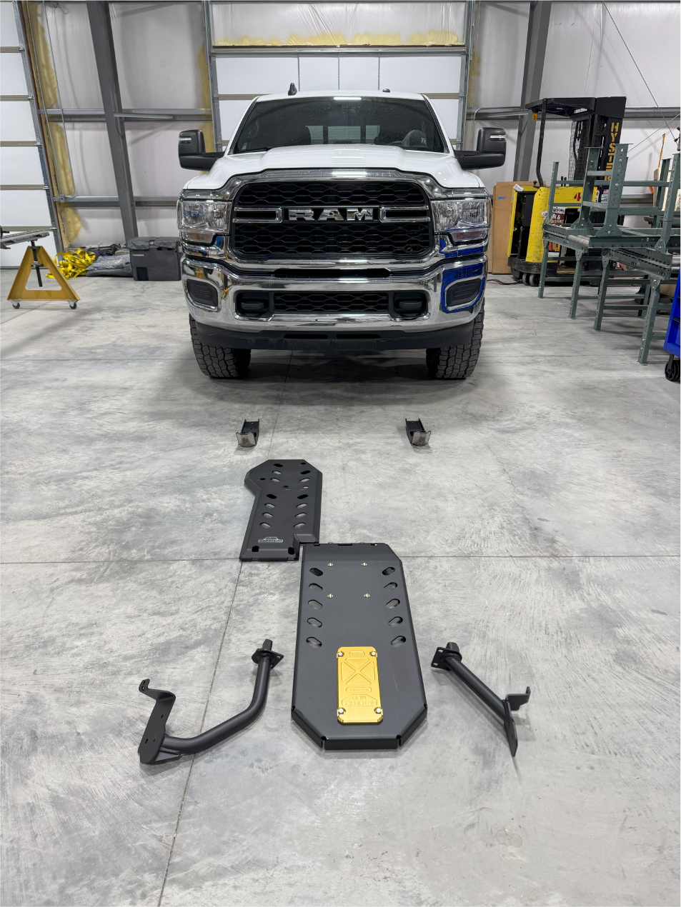 Cummins armor kit laid out on the shop floor in front of a white Ram 2500