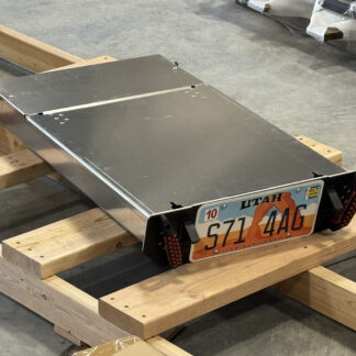 The utility drawer unit on blocks in the shop, closed, license plate mounted to its face