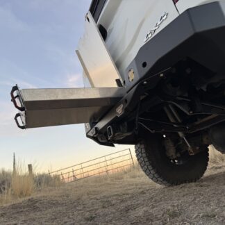 Low view from behind the truck at dusk with the drawer extended, rear axle and underbody in frame