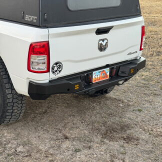 Rear corner of the truck showing the bumper center section, license plate and hitch receiver