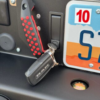 A key in the drawer's barrel lock with a Ram fob hanging from it, red latch handle alongside