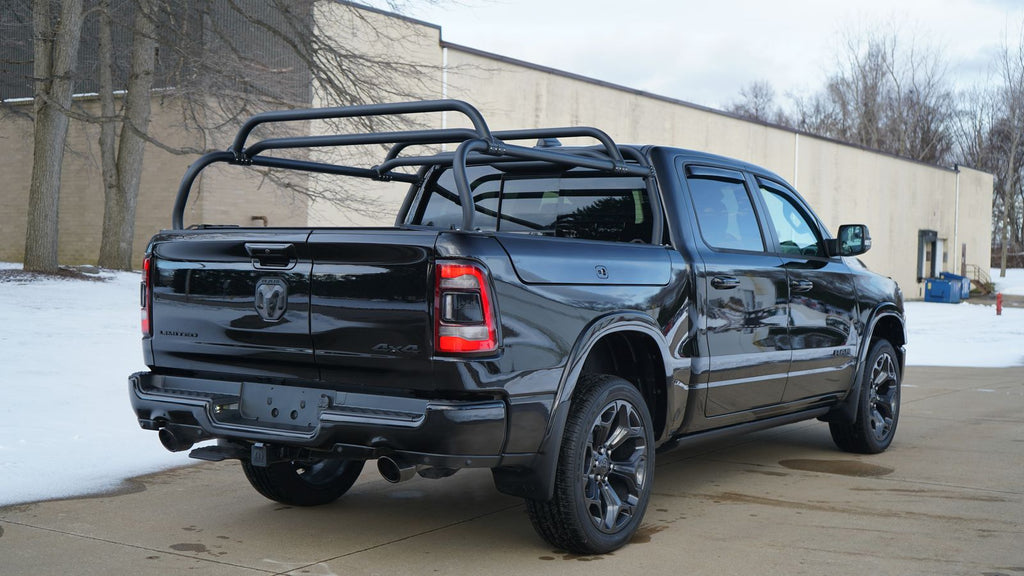 Rear quarter of the black Ram 1500 on a snowy lot, crossbars spanning the rack