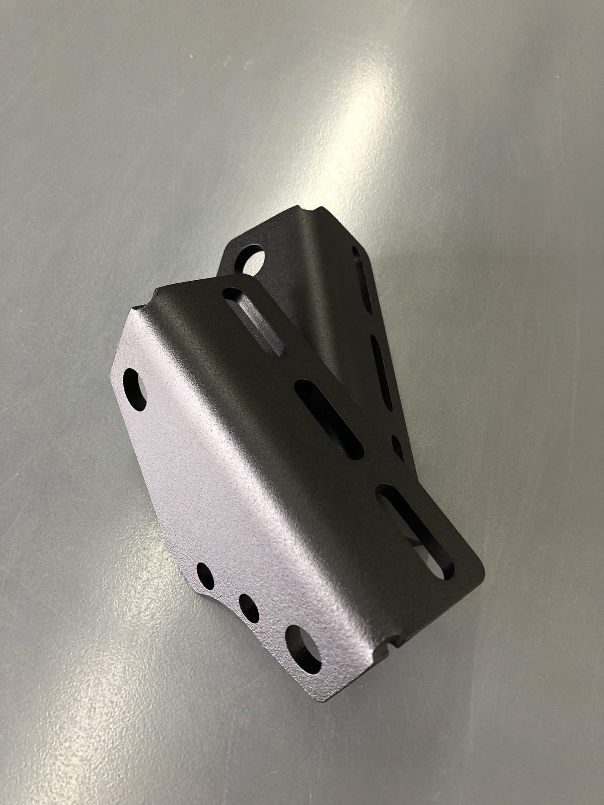 The bracket from a lower angle, showing its folded profile