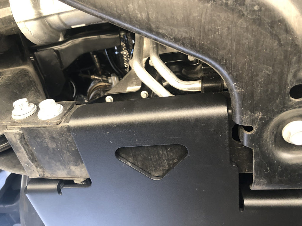The fitted plate at the frame rail, its corner tucked up against the crossmember