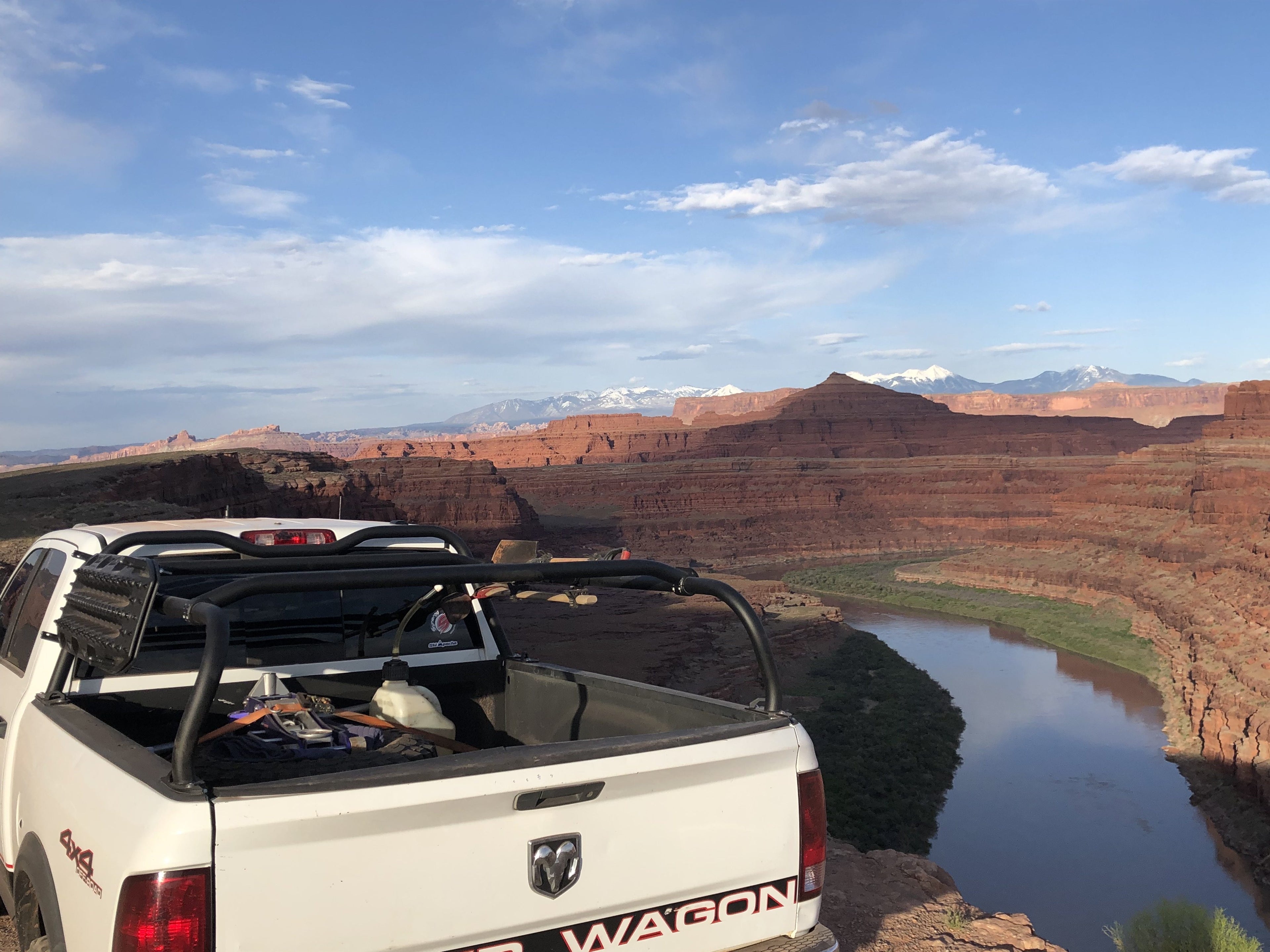 White Power Wagon parked above a river bend, rack loaded and red cliffs beyond