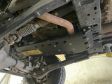 Skid plate installed under a Ram, seen from below with the steering linkage and front axle in frame