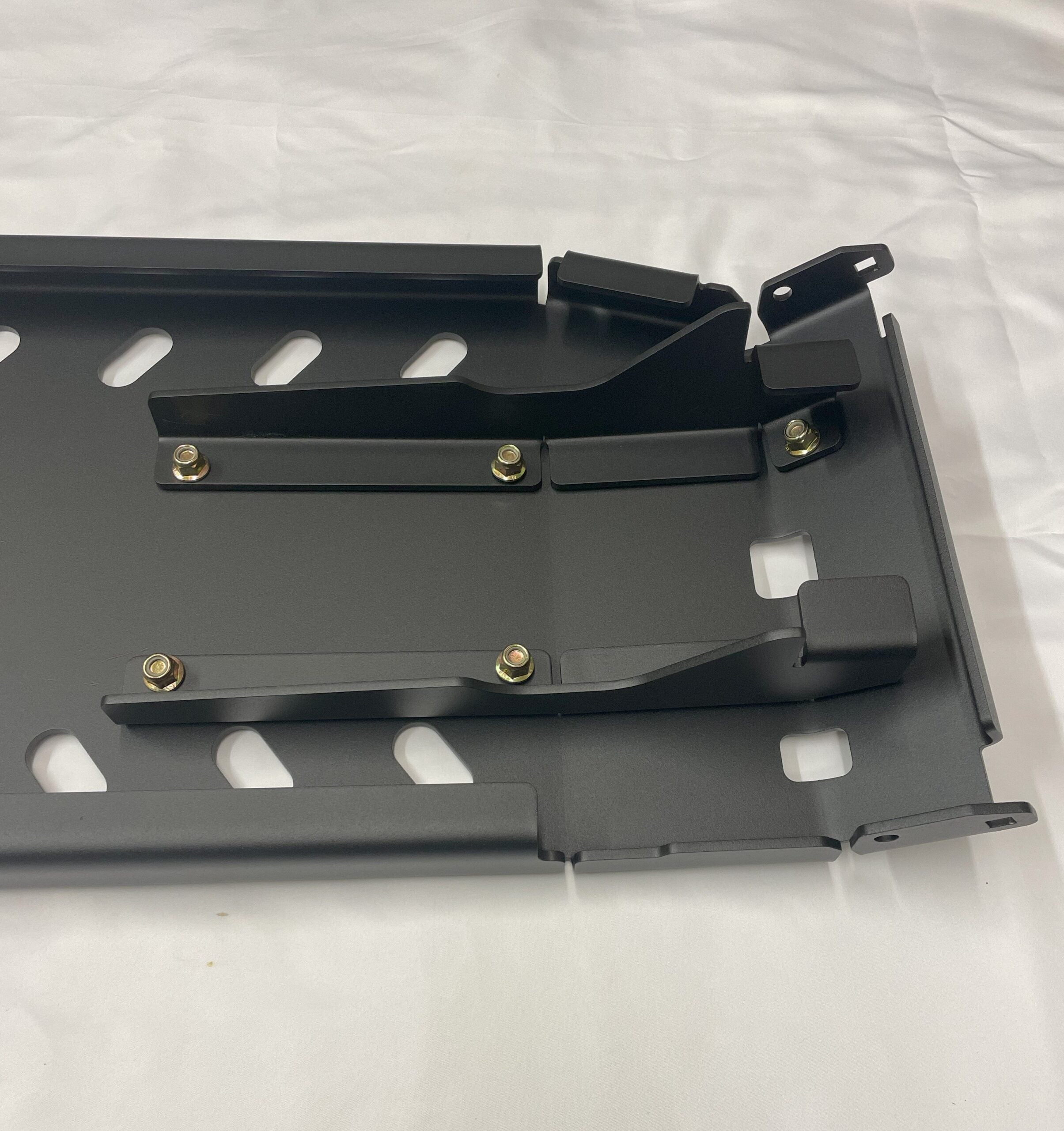 Underside of the skid plate assembly, showing the welded crossmembers and mounting tabs