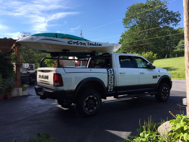 Side view of the white Power Wagon carrying a tandem kayak on the rack