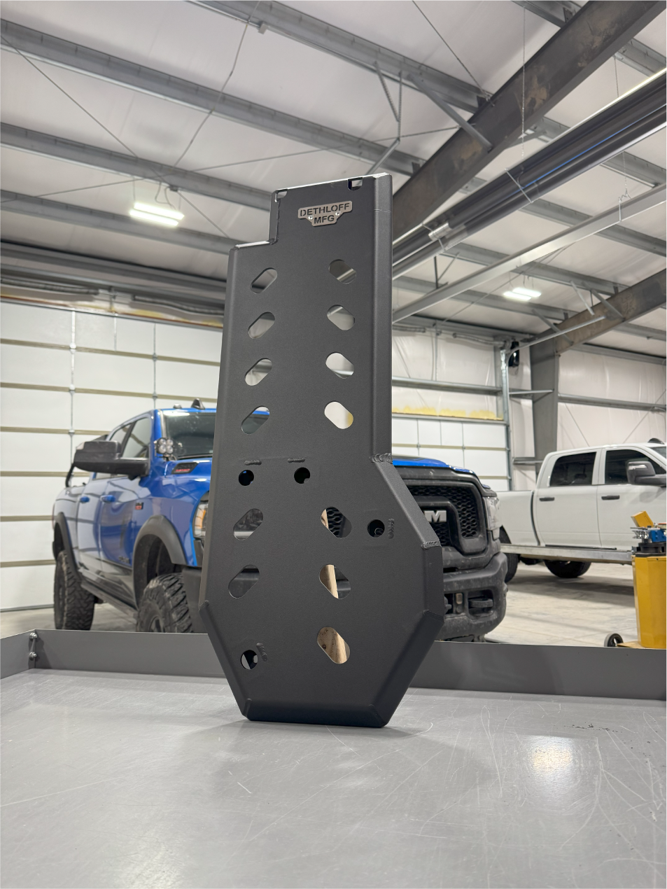 The guard on the bench from a lower angle, trucks in the shop behind