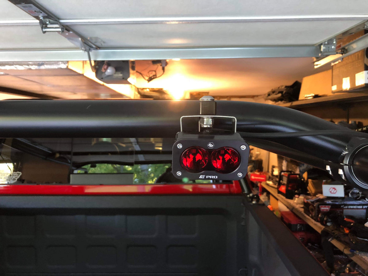 Two amber pods mounted to the rack bar above the bed, garage door open behind