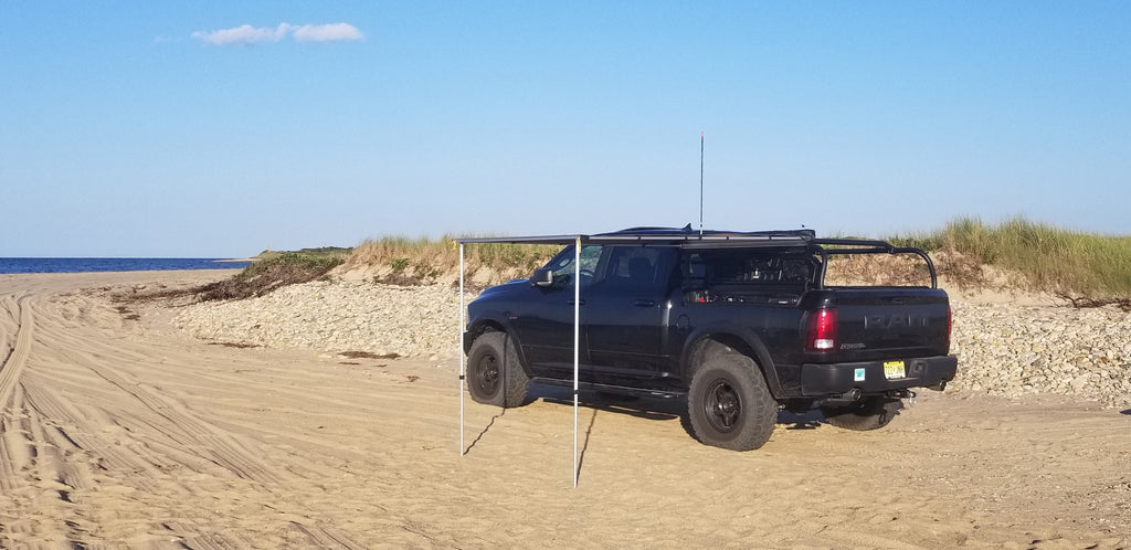 Black Ram on a beach with an awning extended out from the rack