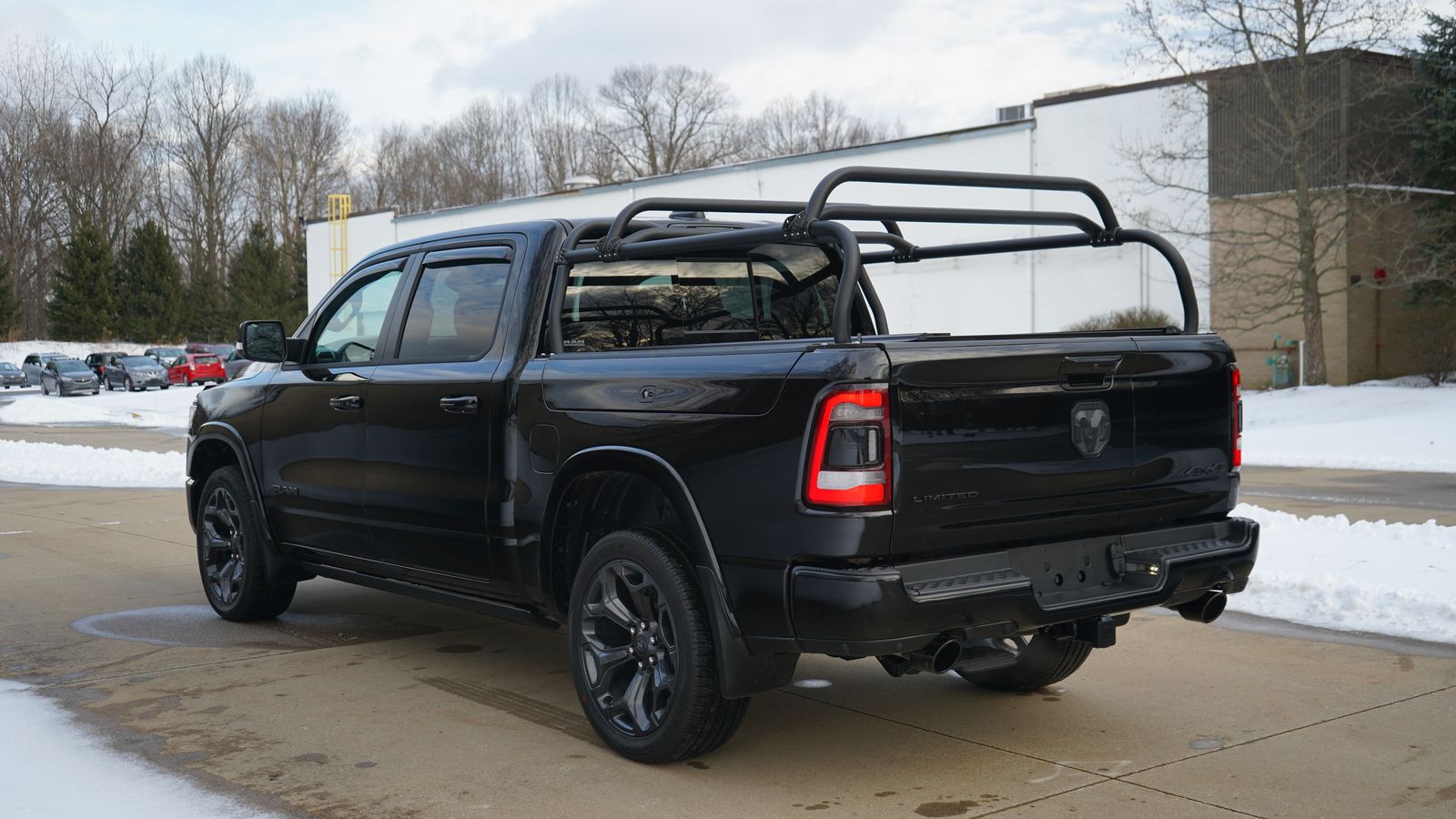 Rear quarter of the black Ram 1500 in winter, rack rails running the length of the bed