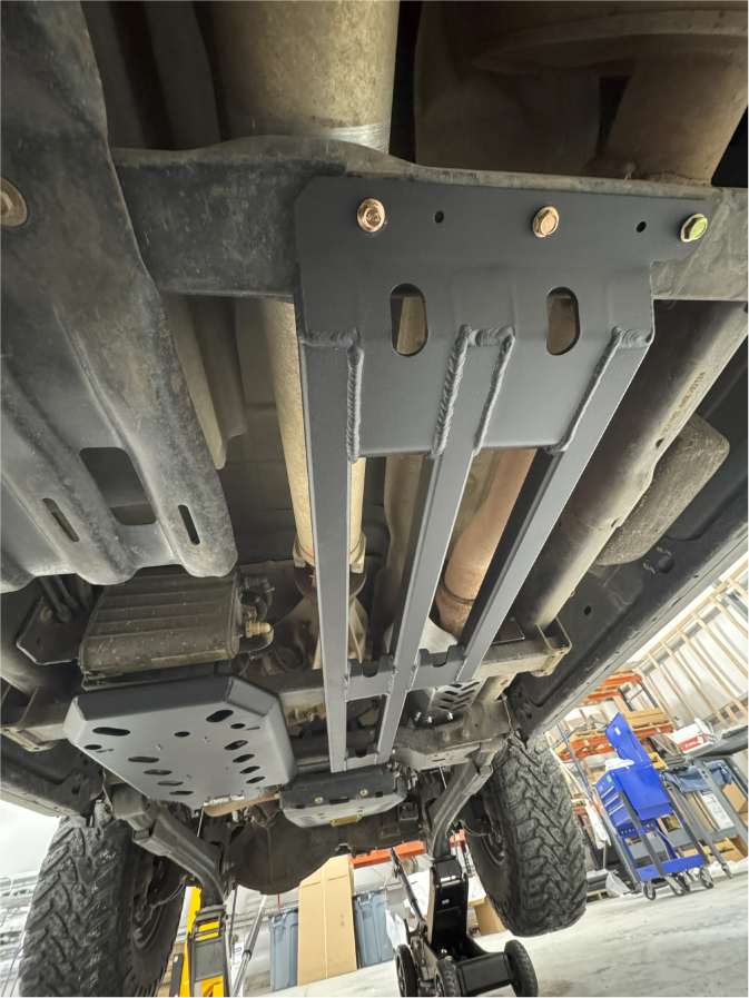 The fitted three-bar guard under the truck, bolts along its front edge