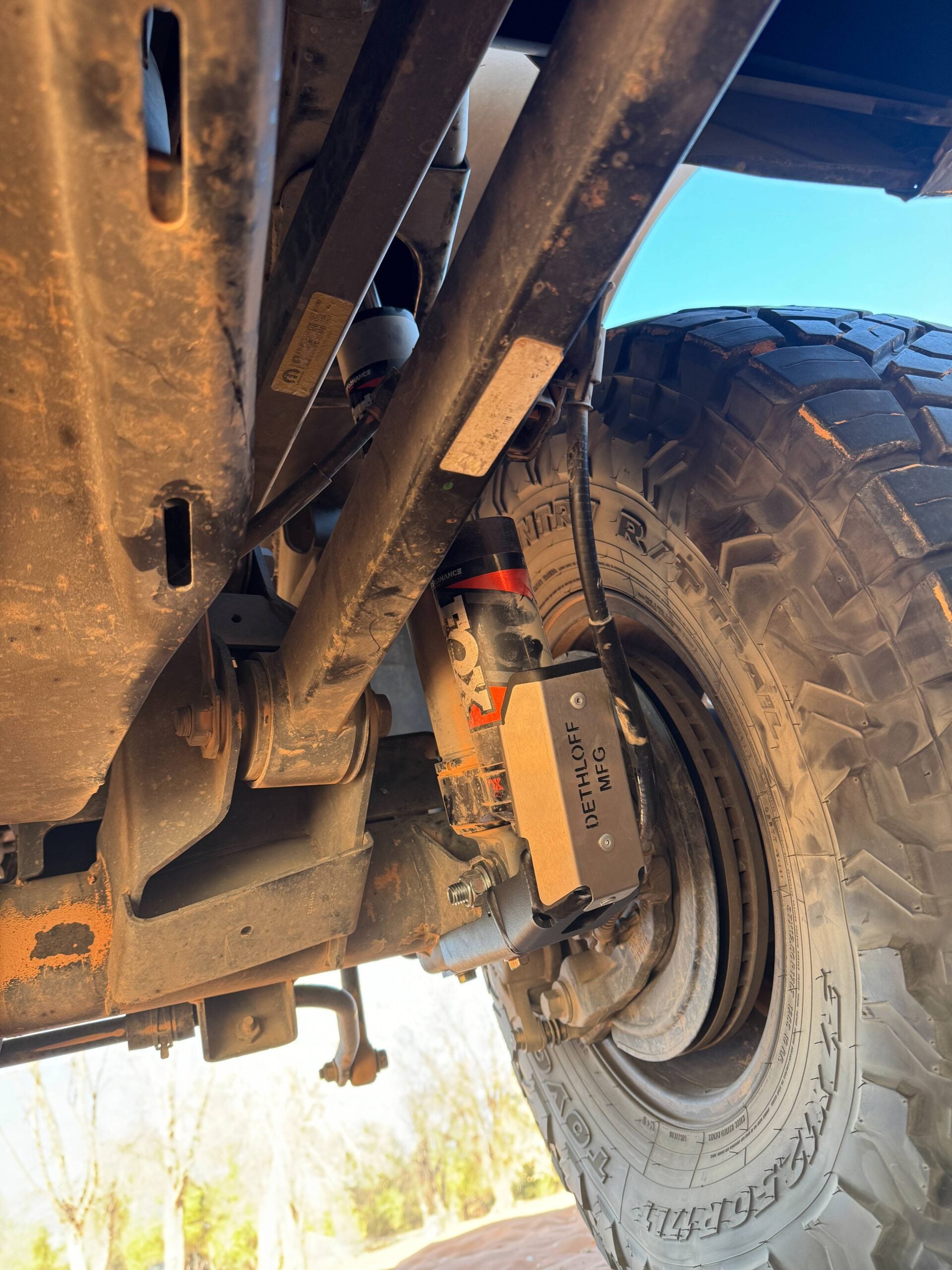 Under the rear of the truck with the guard in place behind the wheel