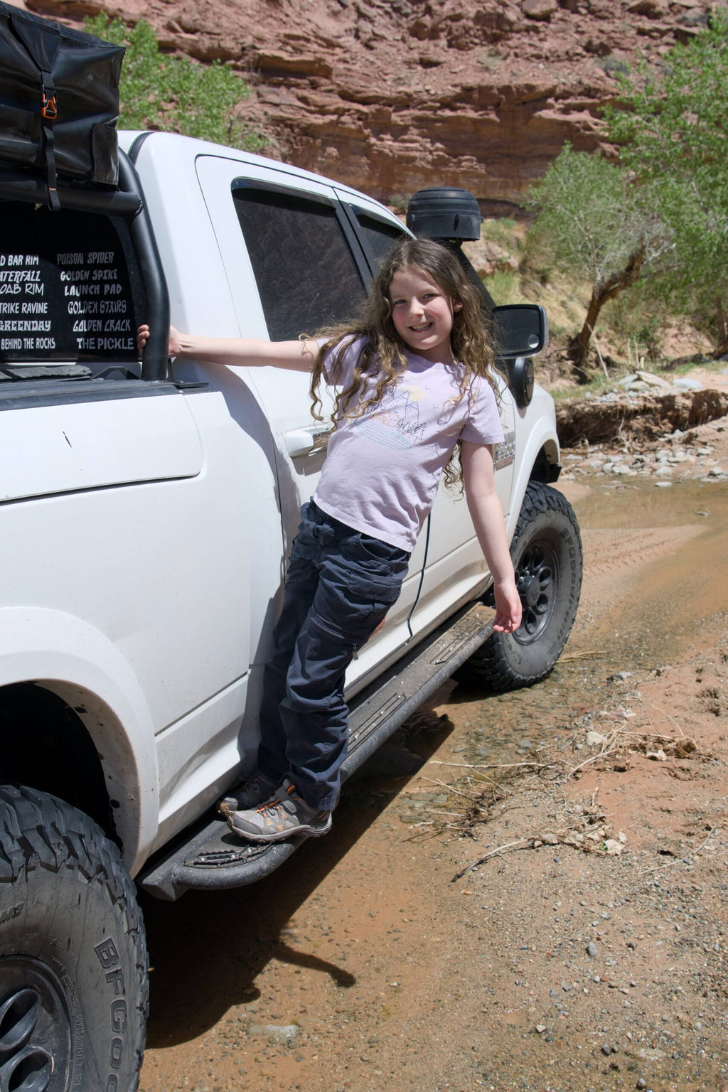 A child standing on the slider to reach the cab, using it as a step