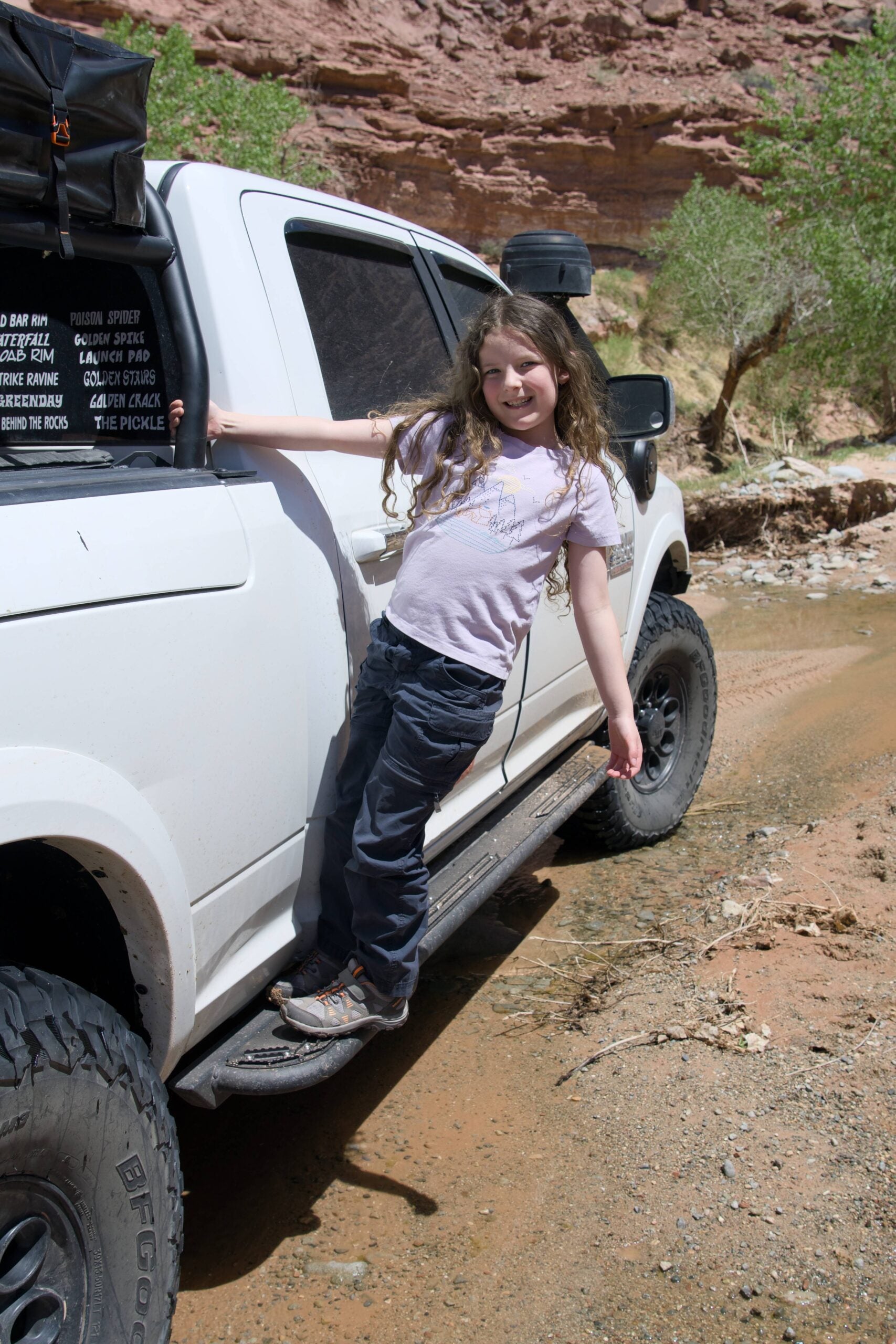 A child standing on the slider to reach the cab, using it as a step